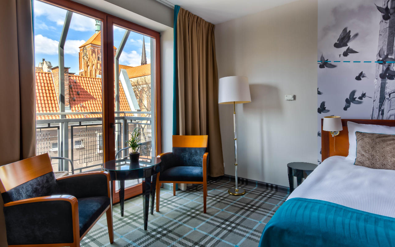A room in the hanza hotel with a view of the church tower in the center of Gdansk